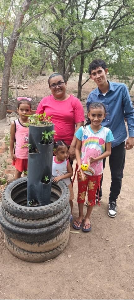 Anielka with her daughter, nieces, and Onal Martín beside their vertical garden