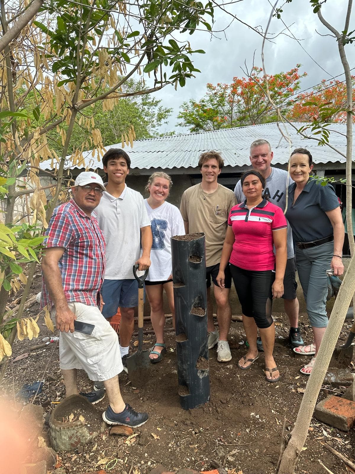 Engineers and community members beside a vertical garden prototype